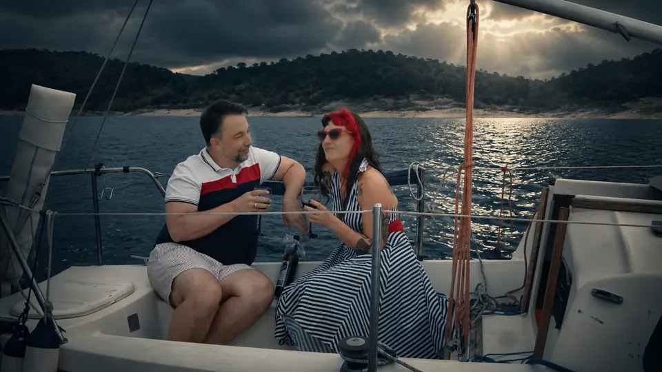 Two characters sharing a drink aboard a sailboat in Flor de Loto